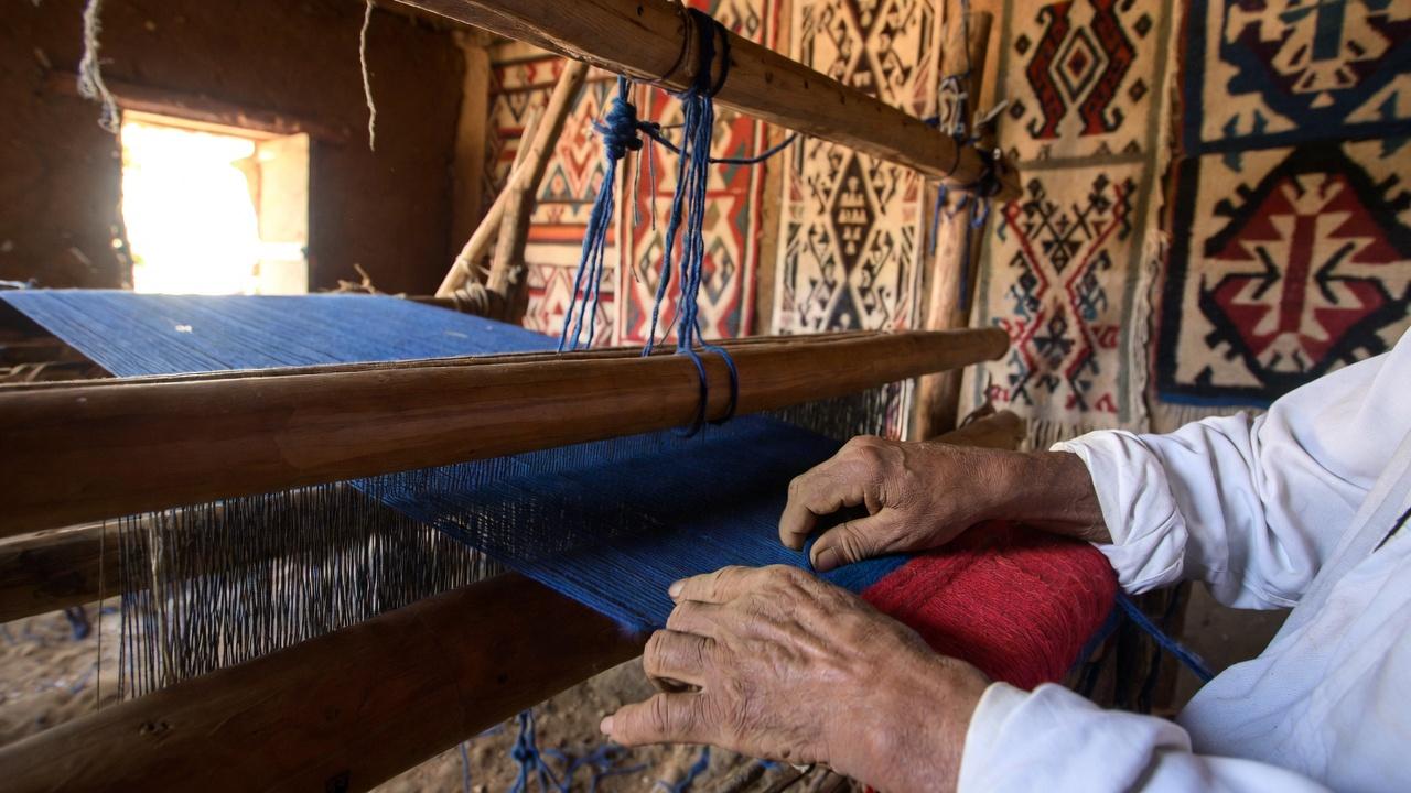 Multicolored handwoven textiles displayed in an Oaxacan market